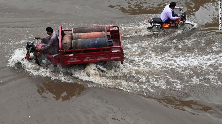 People drive across a flooded street after heavy rainfall in Lahore, Pakistan on July 21, 2022. 